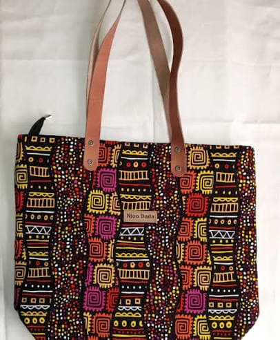 A Njoo Dada tote bag in a bold tribal-print fabric with leather handles.