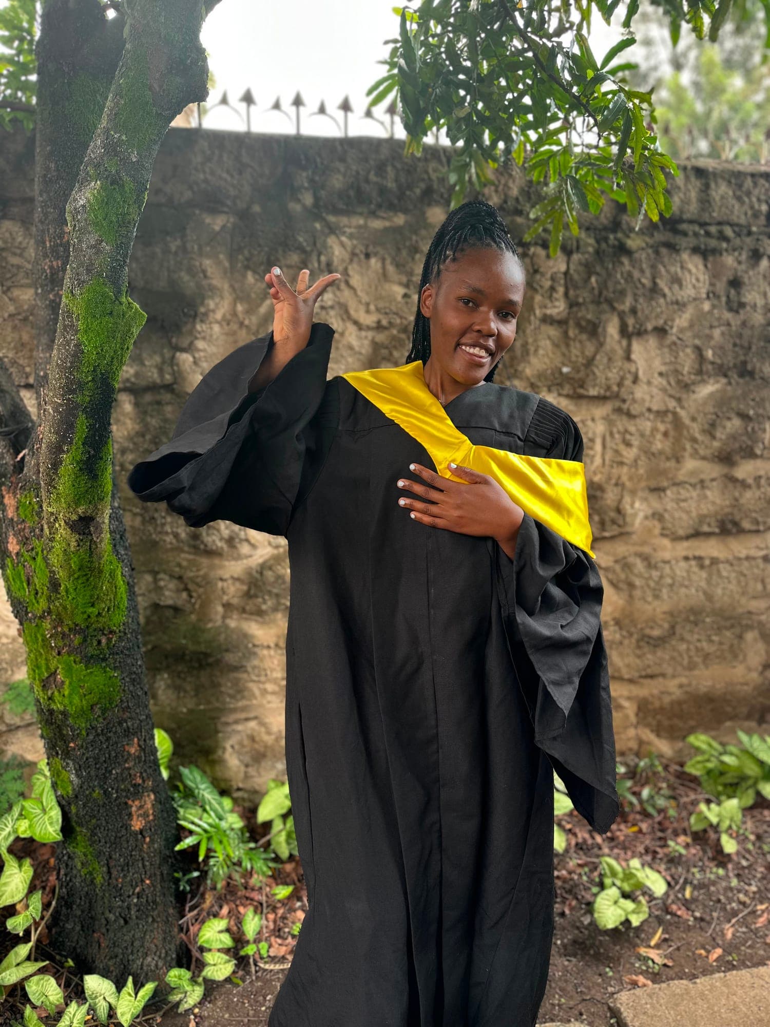 A Njoo Dada participant in cap and gown on her graduation day.